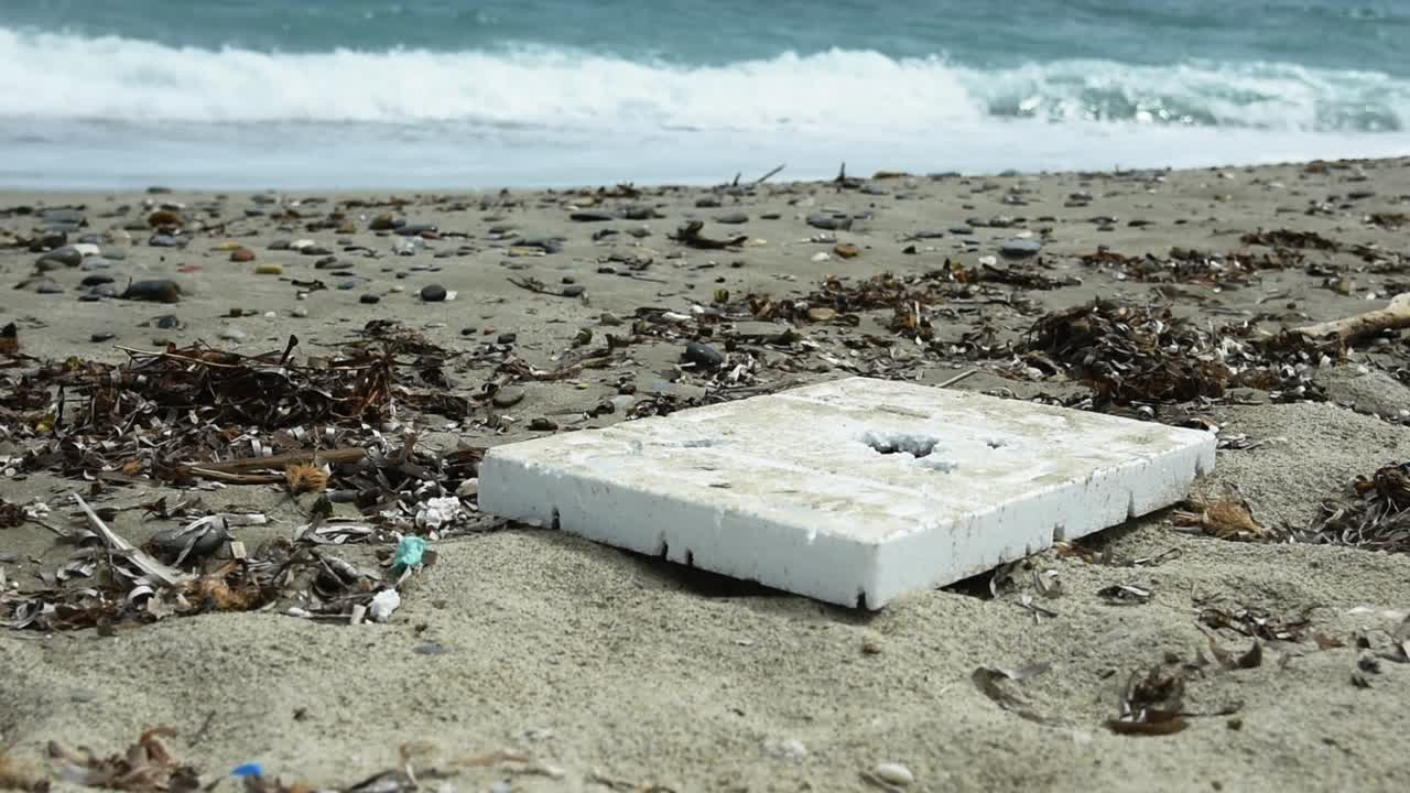 백그라운드에서 파도와 함께 해변에 큰 스티로폼 조각