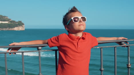 Joyful-boy-relaxing-outdoor.-Cheerful-guy-enjoying-summer-vacation-at-coastline.