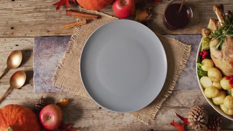 Video of plate, diverse dishes and autumn decoration on wooden surface