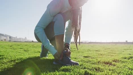 Mujer-Afroamericana-En-Ropa-Deportiva-Atándose-Los-Cordones-De-Los-Zapatos-En-El-Parque