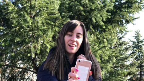 Cámara-Lenta-De-Una-Joven-Que-Se-Toma-Selfies-Con-Un-Smartphone-Usando-Una-Cámara-Frontal-En-Un-Parque-De-La-Ciudad