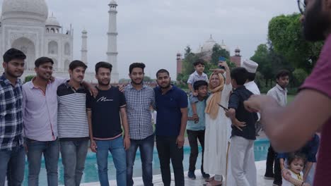 group of friends getting their photo clicked in front of taj mahal