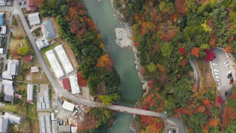 Una-Toma-Aérea-De-4k-De-Un-Hermoso-Río-Poco-Profundo-Durante-Un-Fresco-Día-De-Otoño-En-Un-Pueblo-Rural-Onsen-En-Higashiomi,-Prefectura-De-Shiga,-Japón