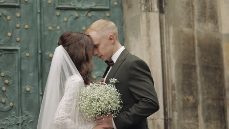 recién casados, novio caucásico con novia caminando, abrazándose, abrazándose en la ciudad, pareja de bodas enamorada
