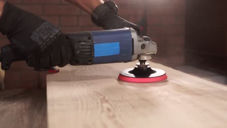 man sanding a wooden plank with a power sander