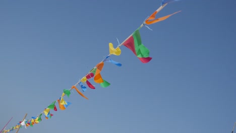 slow motion colorful pennant banner crowd control rope against blue sky