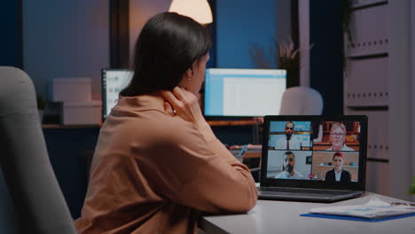 Overworked-businesswoman-discussing-with-remote-partners-on-laptop