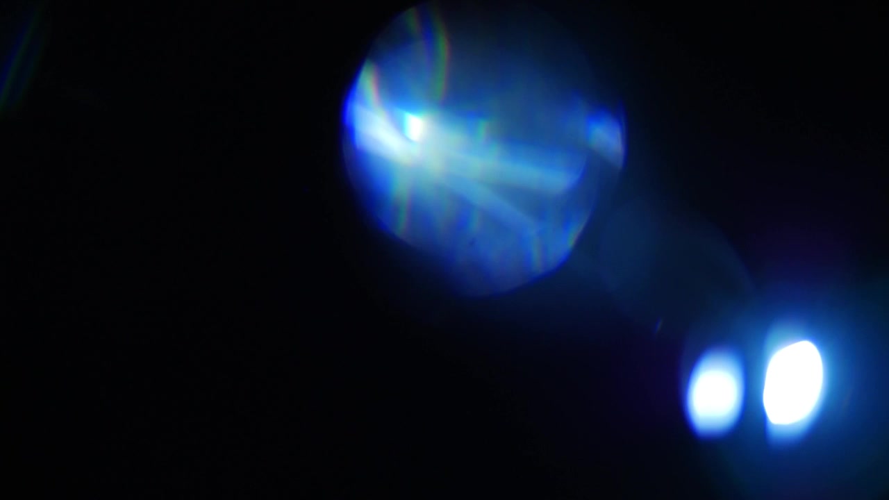 Perdite di luce blu astratte e bagliori dell'obiettivo in movimento su sfondo nero