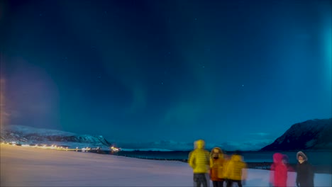 person proposing to his girl with his friends while watching the northern lights in winter. time lapse
