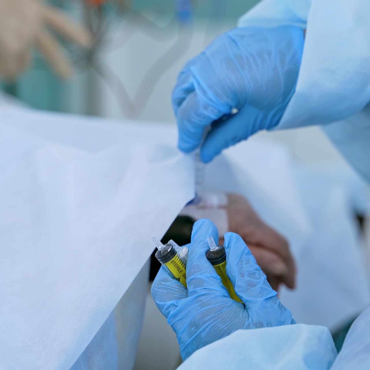 Nurse's hands in sterile gloves near patient's hand. Medical worker injects during the saving patient's life in clinic. Close-up. Coronavirus. Epidemiology concept.