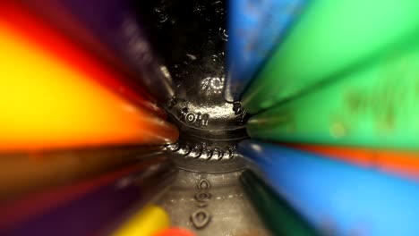 moving out of a jar of colored pencils where the bottom of the jar is in focus and the pencils blend as they move above