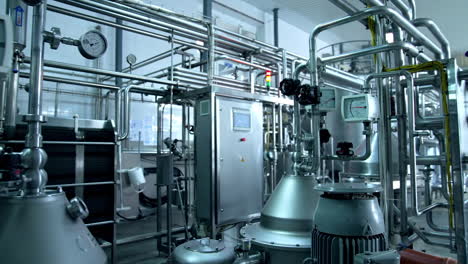 ?omplex pipe system with sensors at milk production factory. ramified pipeline system for dairy manufacturing company. big light premise with tanks and pipes for milk factory.