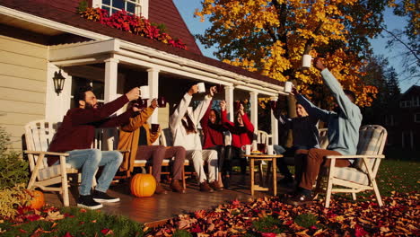 friends celebrating and toasting on a cozy autumn porch