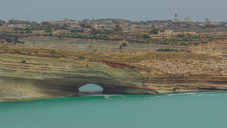 Timelapse-Que-Captura-El-Movimiento-Del-Agua-Frente-Al-Arco-De-Roca-De-La-Ventana-Hofriet-En-La-Costa-De-Malta