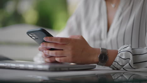close-up of a woman typing on a mobile phone screen while sitting in a summer cafe. internet banking surfing mobile sites