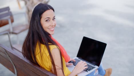 Young-woman-sitting-on-an-urban-bench