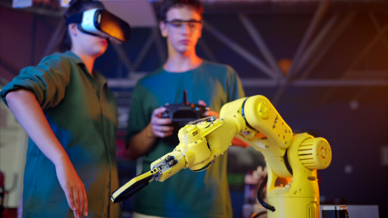 Young engineers with VR virtual reality headset controlling an yellow robotic arm in research laboratory