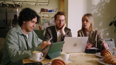 three people in a coffee shop having a business meeting