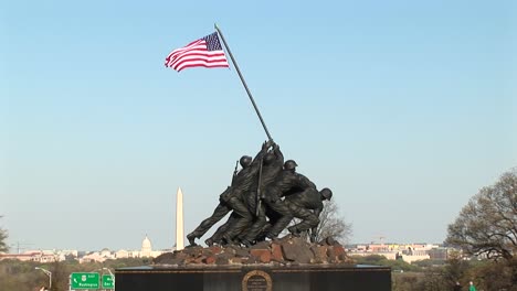 the iwo jima marine corps memorial stands tall with the washington monument faintly in the background