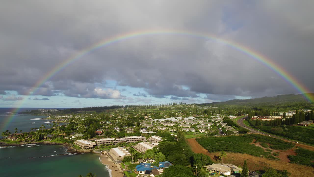 arco iris vibrante perfecto sobre la costa tropical y hoteles con nubes grises, maui