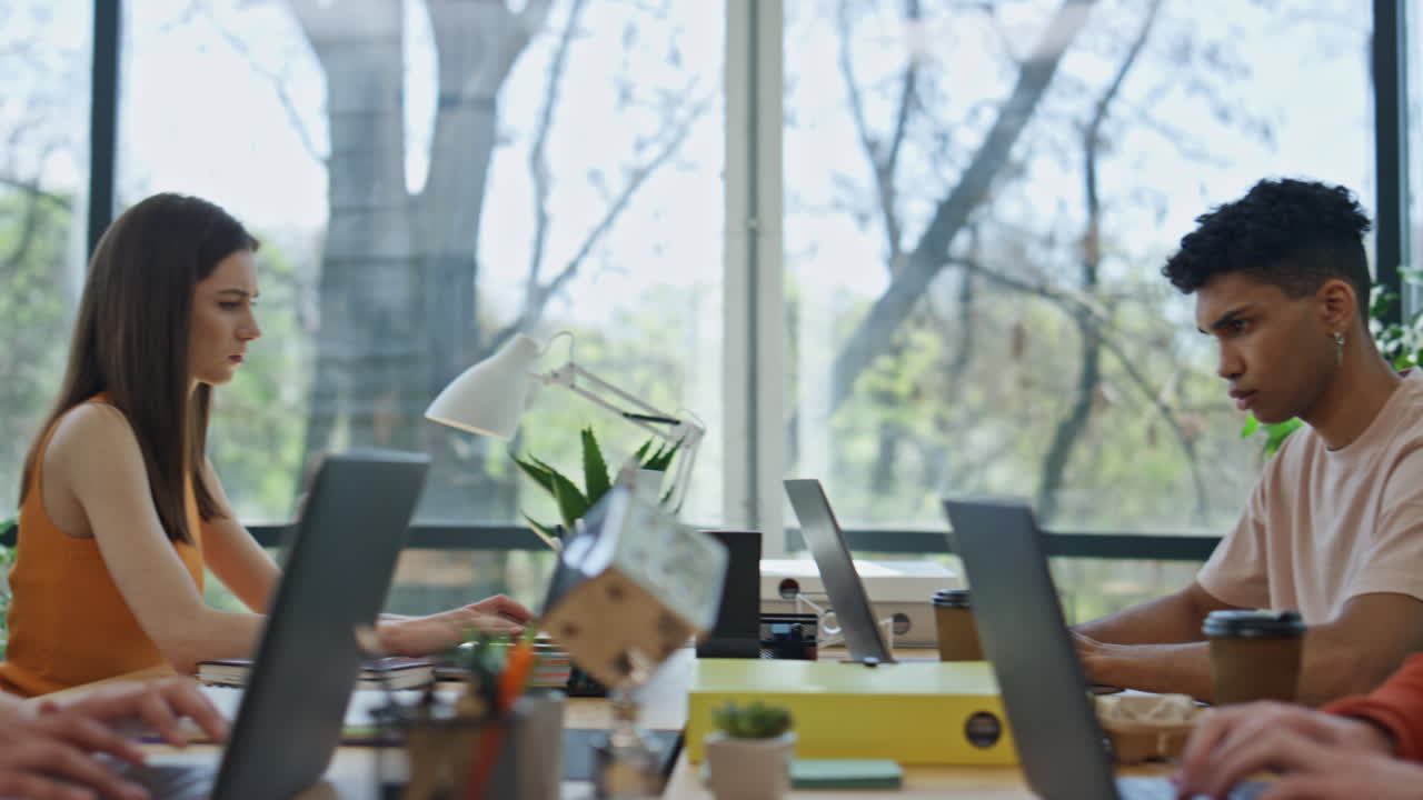 다민족 개발자들이 사무실에서 노트북을 코딩하고 있습니다. 스타트업 팀이 함께 일하고 있습니다.