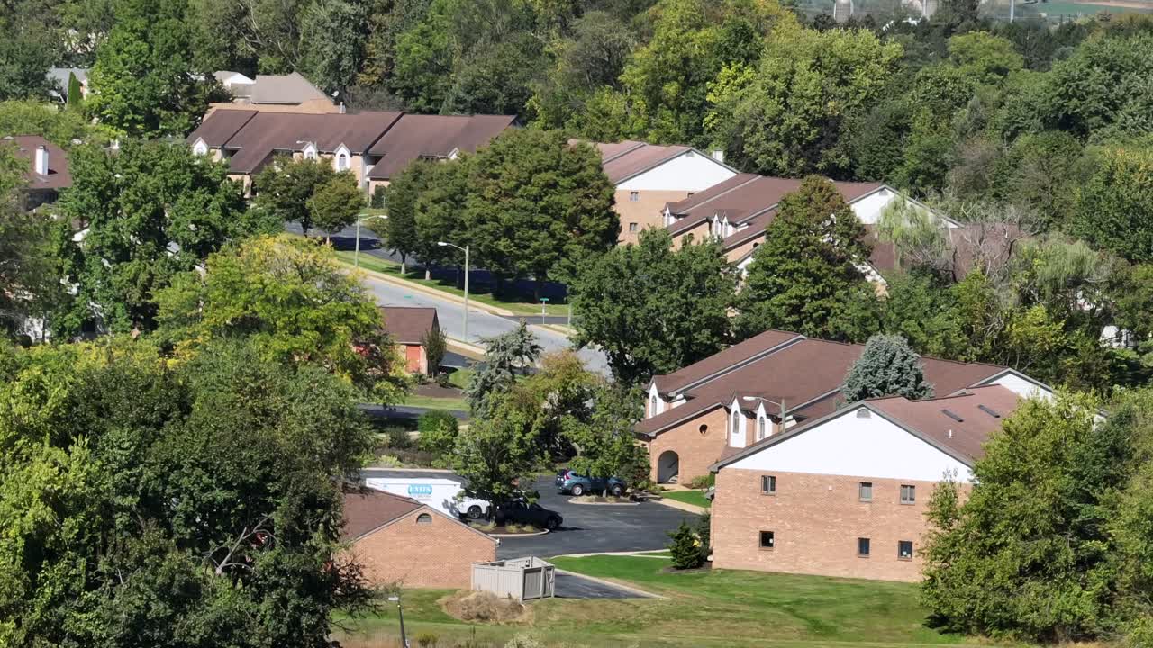 Row of american houses in green lush suburbia. Aerial wide shot. Sunny day in fall season. Serene atmosphere landscape of USA