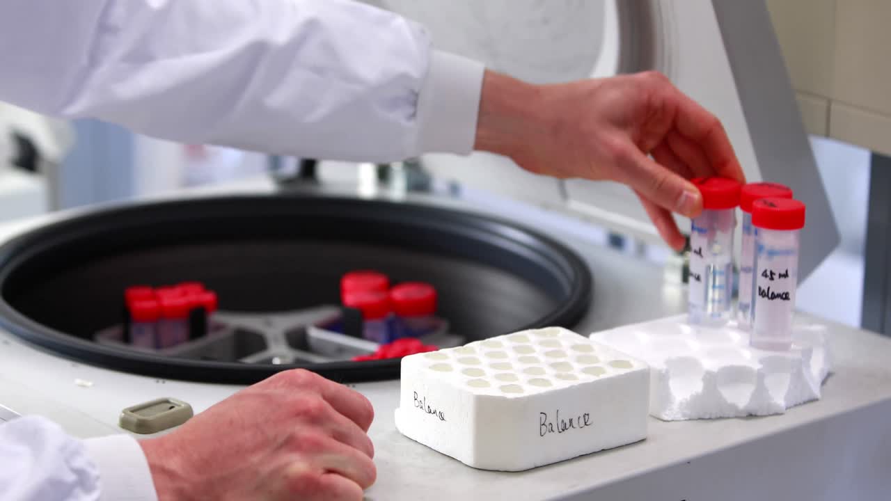 Scientist placing test tubes in centrifuge