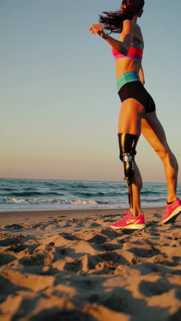 athlete with prosthetic leg running on the beach at sunrise or sunset