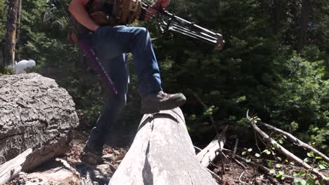 archers walking over a log in the mountains