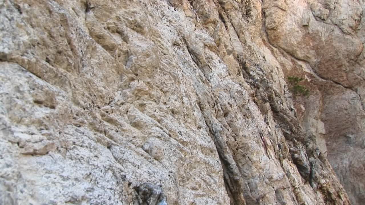 panright de un escalador escalando laboriosamente una roca de granito