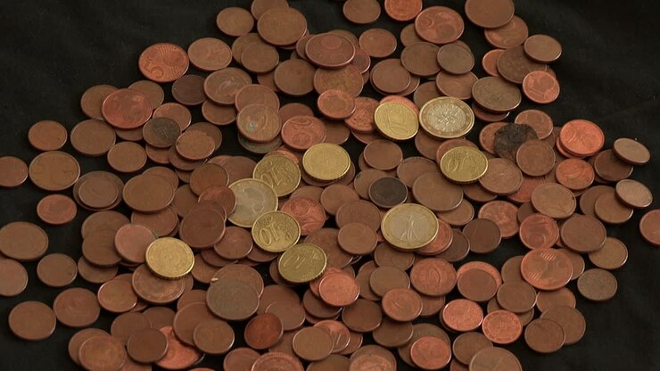 Diverse monete sparse su un panno nero, monete da 1 euro e molte altre da 20, 10, 5, 2, 1 centesimo