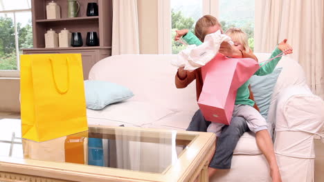 cute little girl looking at shopping purchases with her mother
