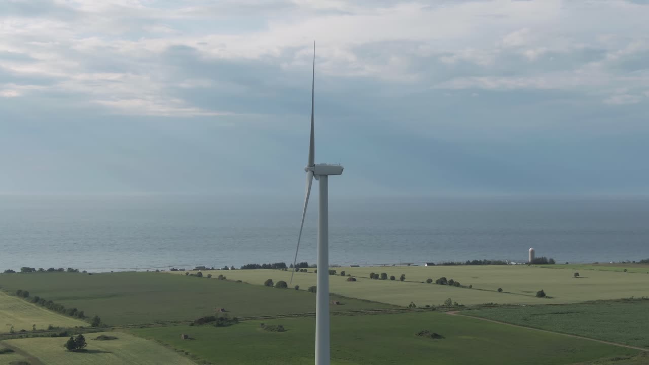 Wind Turbine Generating Energy On The Wind Farm With Saint Lawrence River And Bright Sky On The background In Northern Quebec, Canada. - aerial arc shot