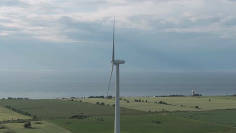wind turbine generating energy on the wind farm with saint lawrence river and bright sky on the background in northern quebec, canada. - aerial arc shot