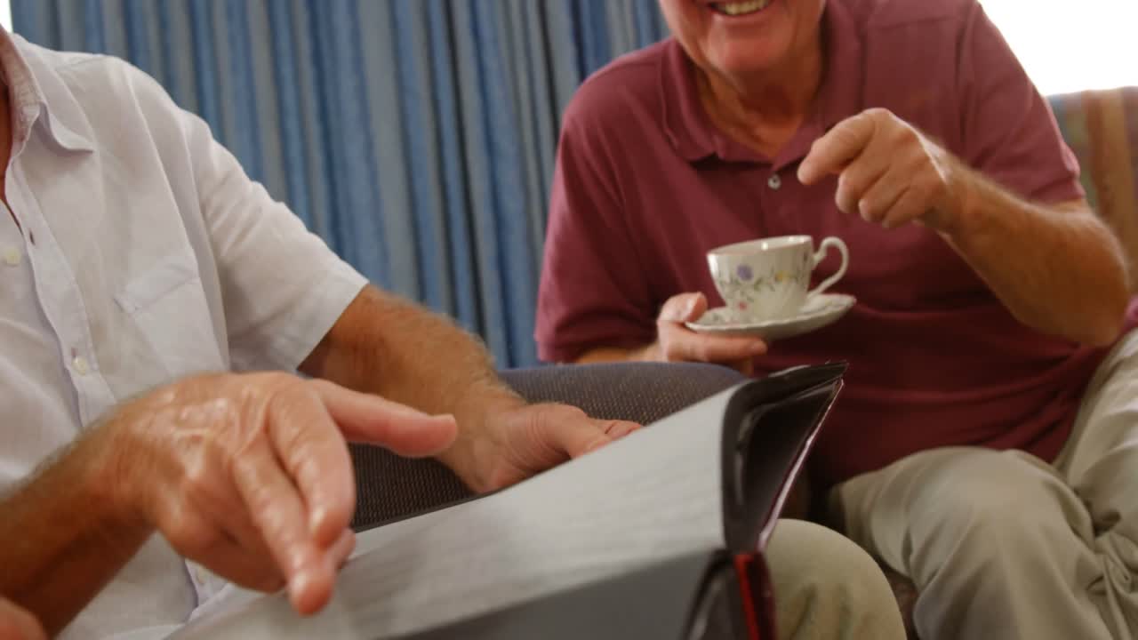 amigos mayores felices mirando un álbum de fotos
