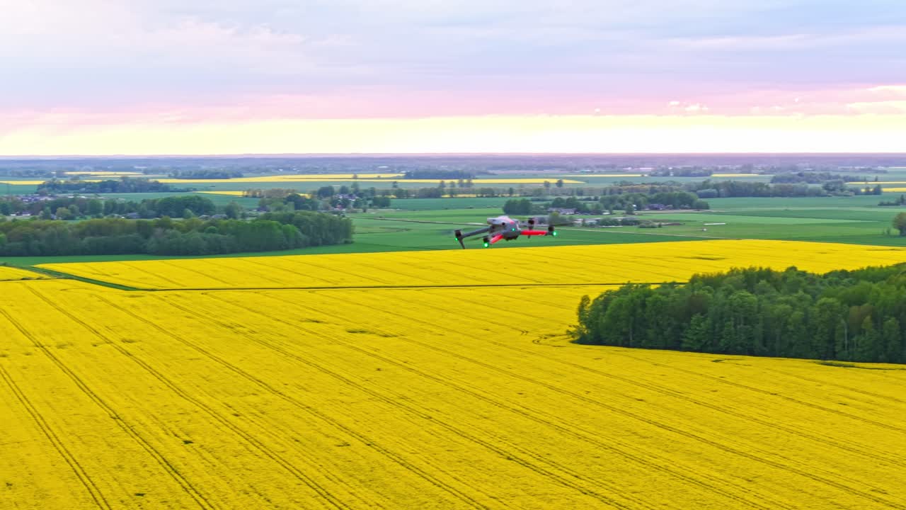 Aerial orbital flight over rural farmland. POV from second drone camera