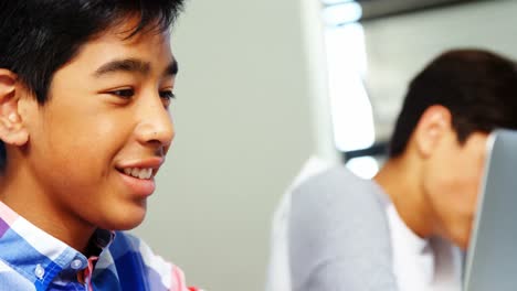 student using laptop in classroom