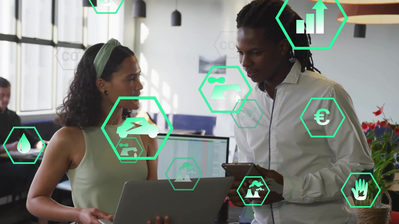 Coworkers using laptop and tablet starting green icons review assessing impact at office