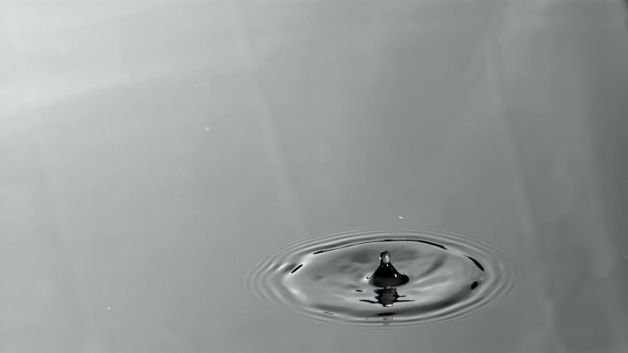 Goccia d'acqua che cade al rallentatore e crea increspature