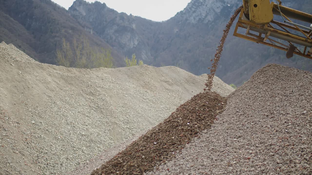Close-up view when a machinery in quarry sorts rock and pouring gravel.