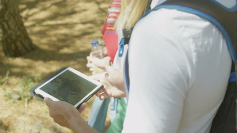 Ein-Paar-Rucksacktouristen-Nutzen-Ein-Digitales-Tablet-Mit-Karte