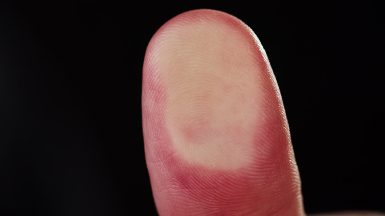 Primo piano del polpastrello umano che rivela un modello unico di impronta digitale