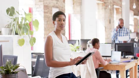 Portrait-of-happy-african-american-colleagues-with-tablet-in-creative-office-in-slow-motion