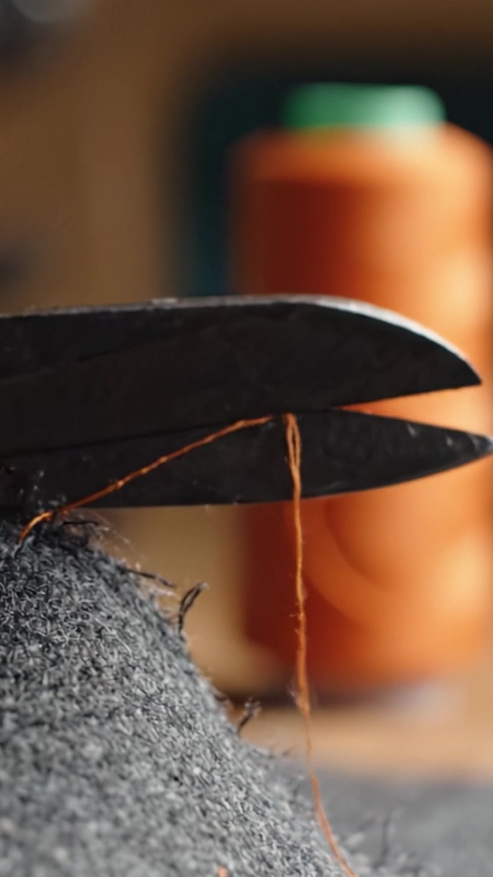 Precision Cutting of Thread: A Craftsmanship Moment Captured with Scissors and Thread Highlights, Showcasing the Detail in Textile Work and Handicrafts