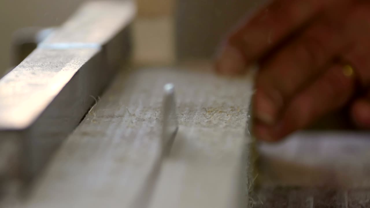 trabajador cortando tabla de madera con sierra circular en una fábrica de muebles