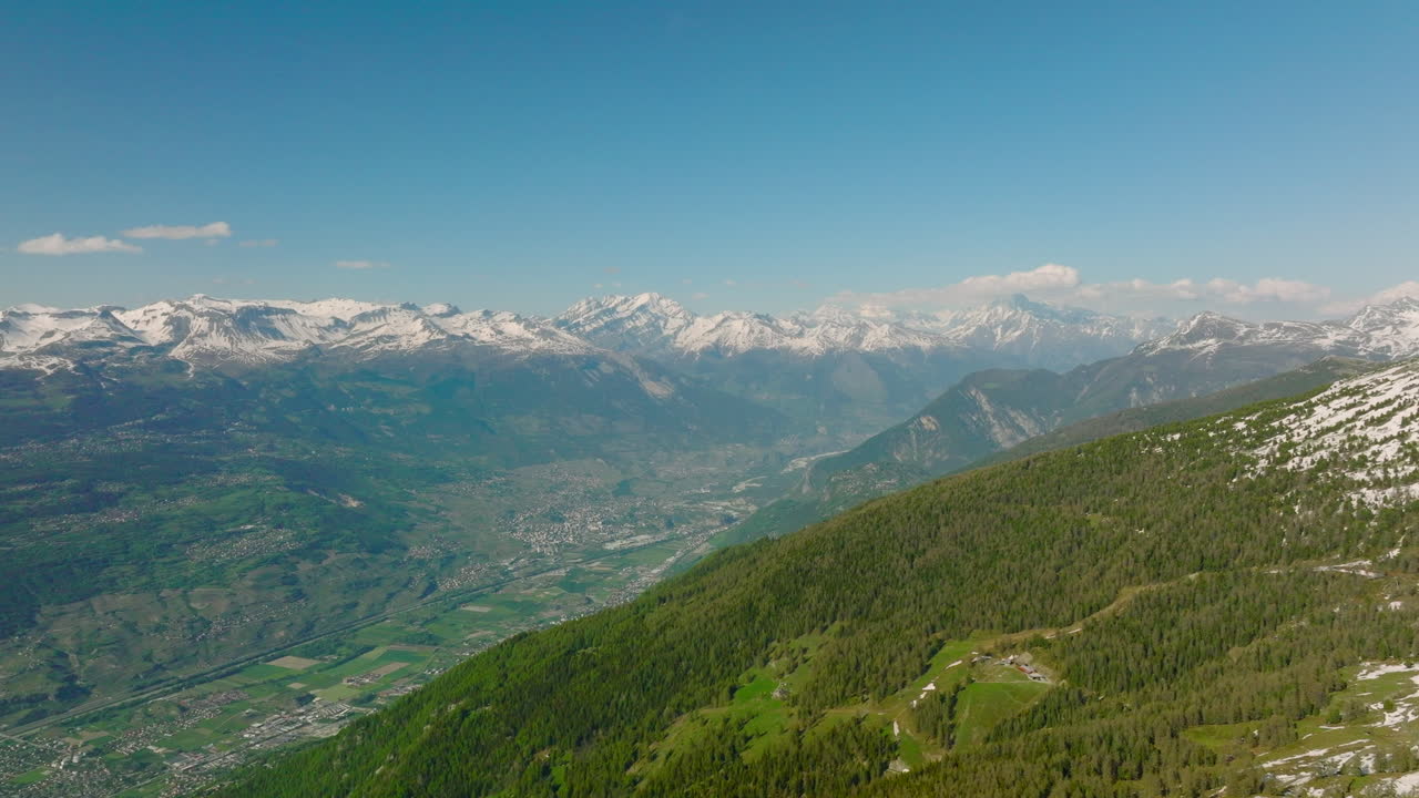 Foresta verde sulla Valle del Rodano con la città di Sierre in lontananza nel Vallese, Svizzera.