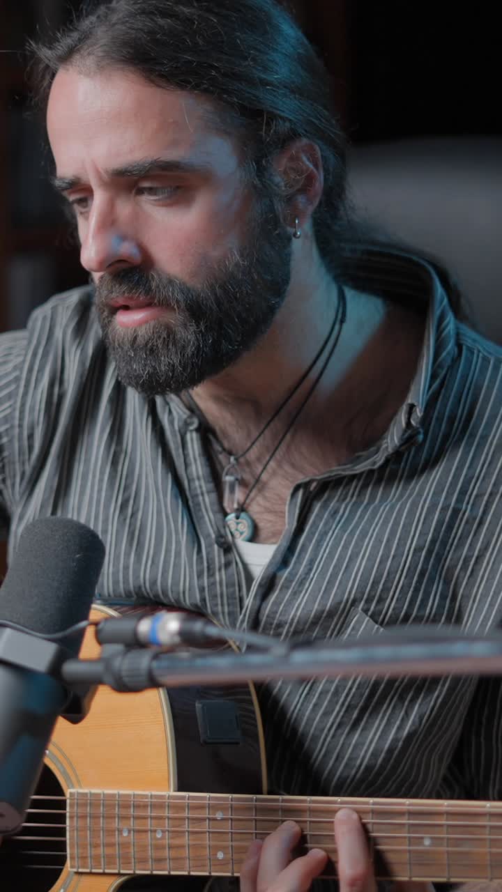 Man playing acoustic guitar in a recording session