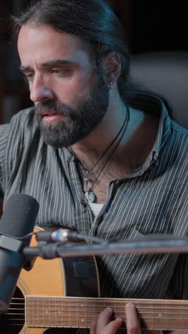 man playing acoustic guitar in a recording session
