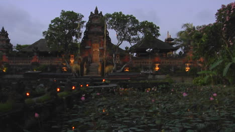 lights flicker on the grounds of a temple in bali indonesia