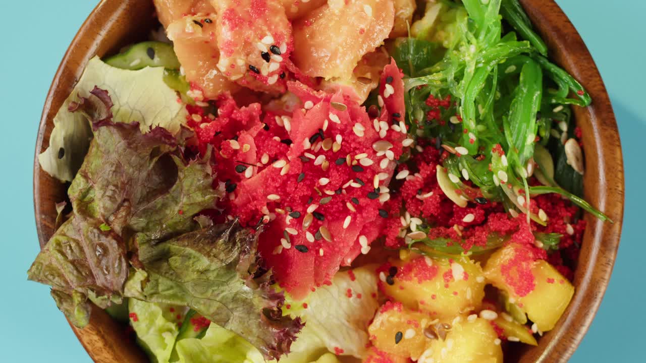 Poke bowl di salmone fresco con mango e alghe in rotazione.